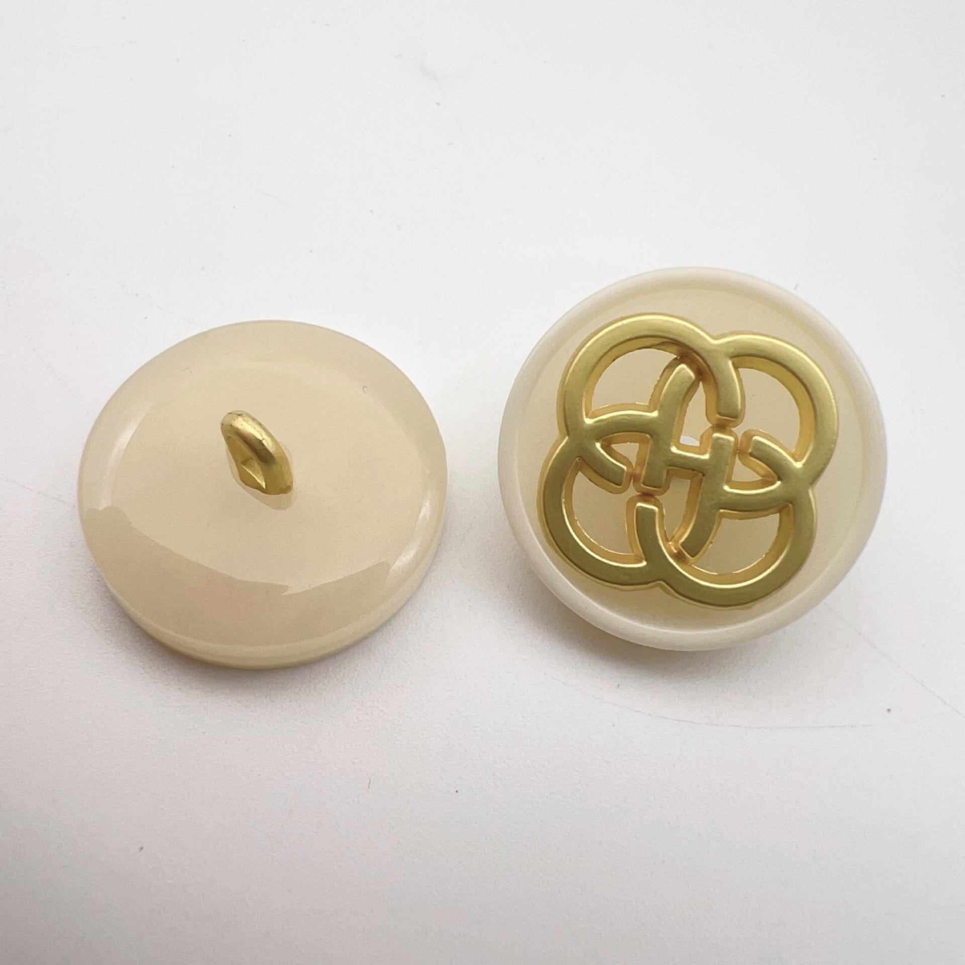 Cream resin button with gold-tone four-leaf clover shank