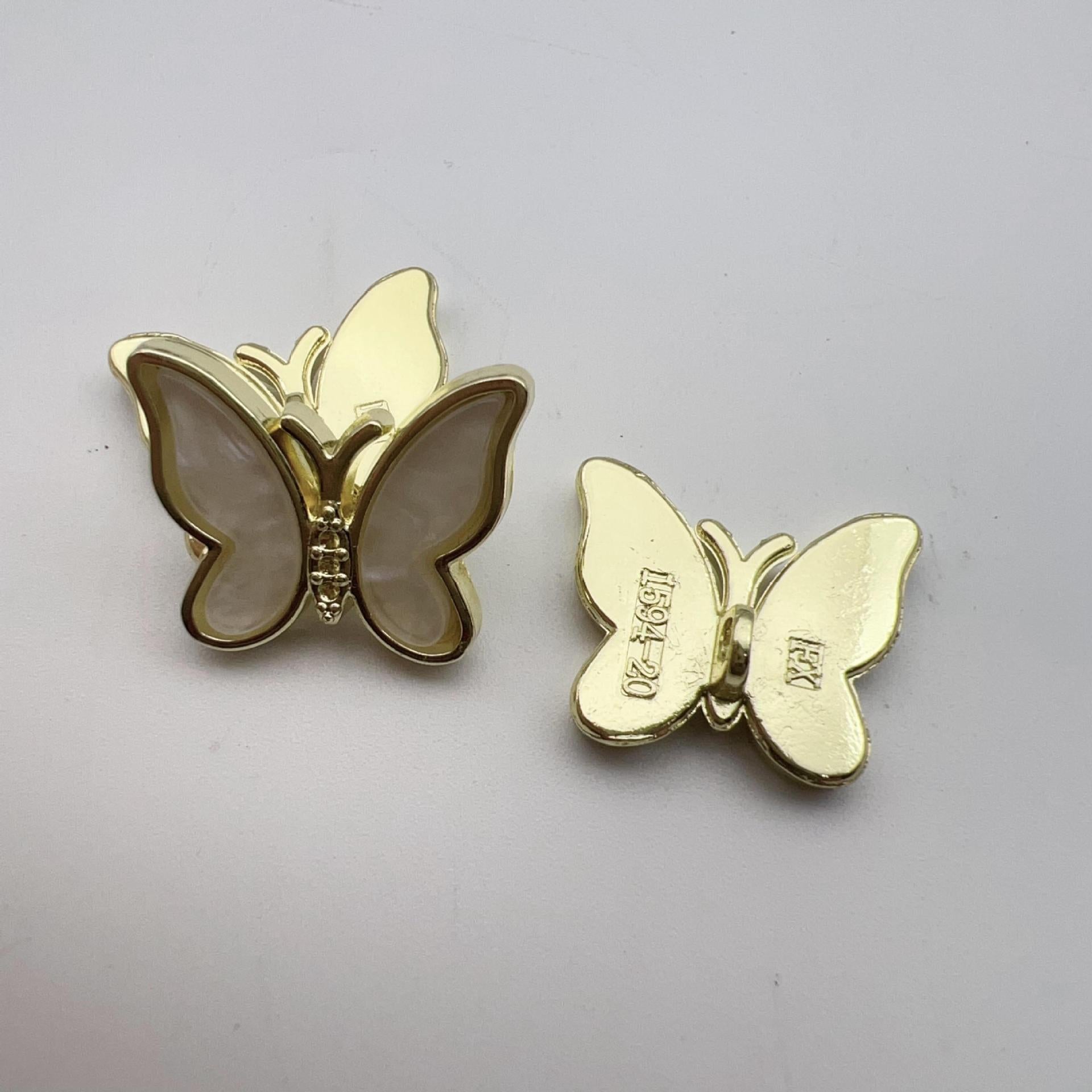 Khaki butterfly shank button pair with gold-tone trim and glossy light centers