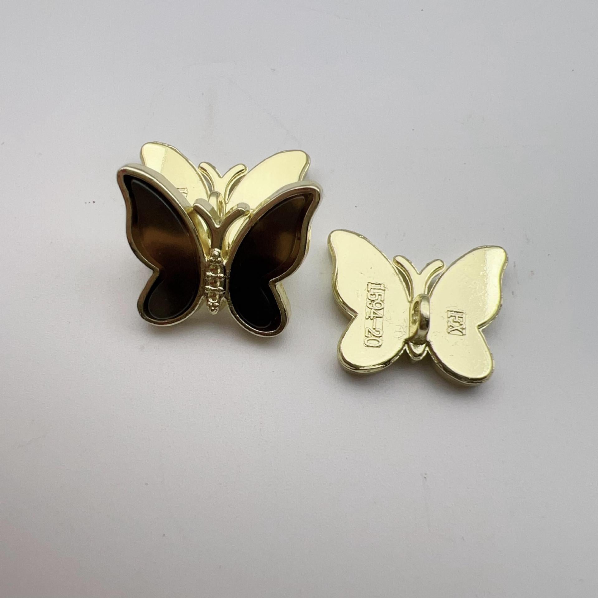 Brown butterfly shank button pair with gold-tone edging and dark glitter centers