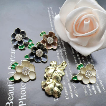 Plum blossom shank buttons set: dark petals with green enamel accents and rhinestone centers