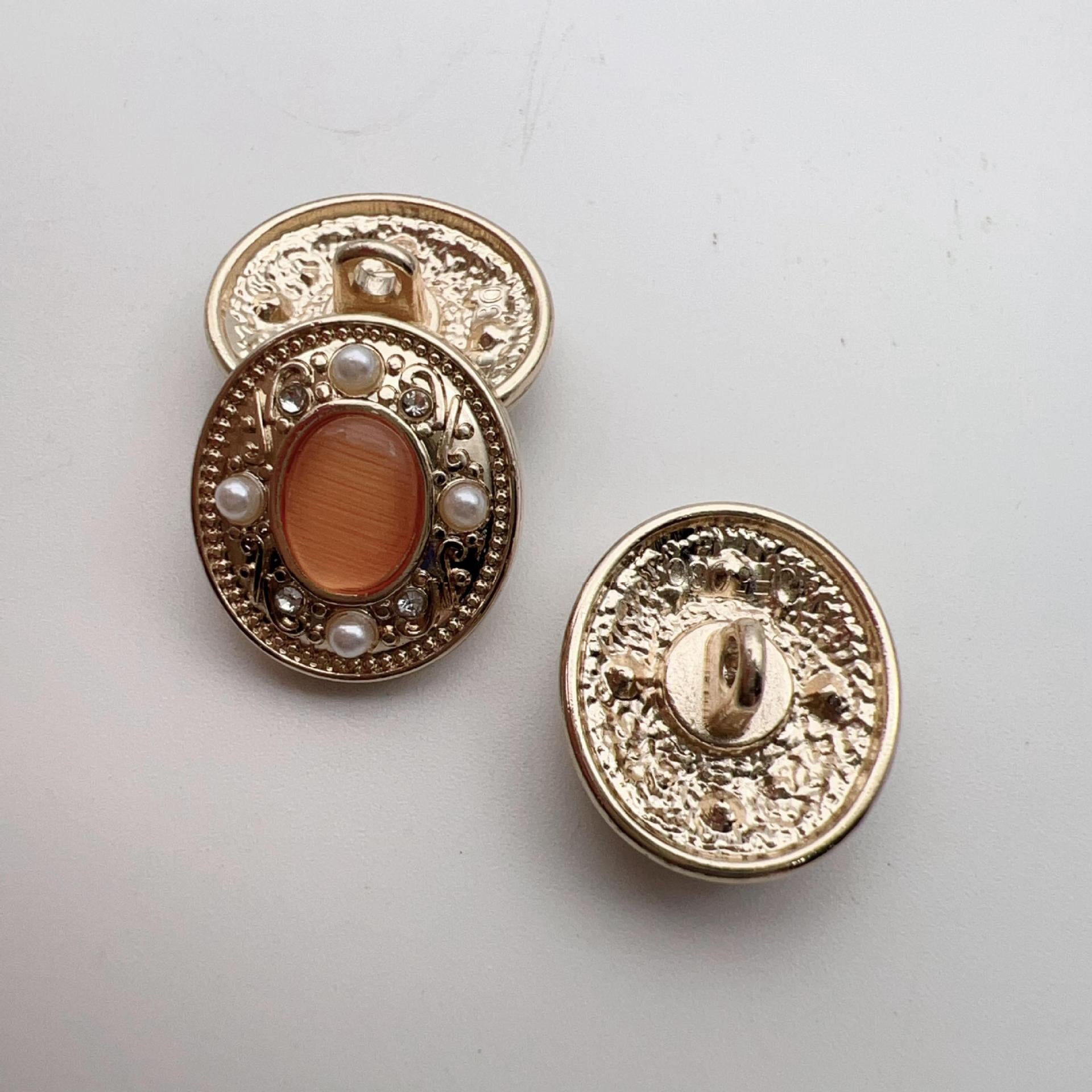 Button backs: gold-tone filigree oval setting with metal shank