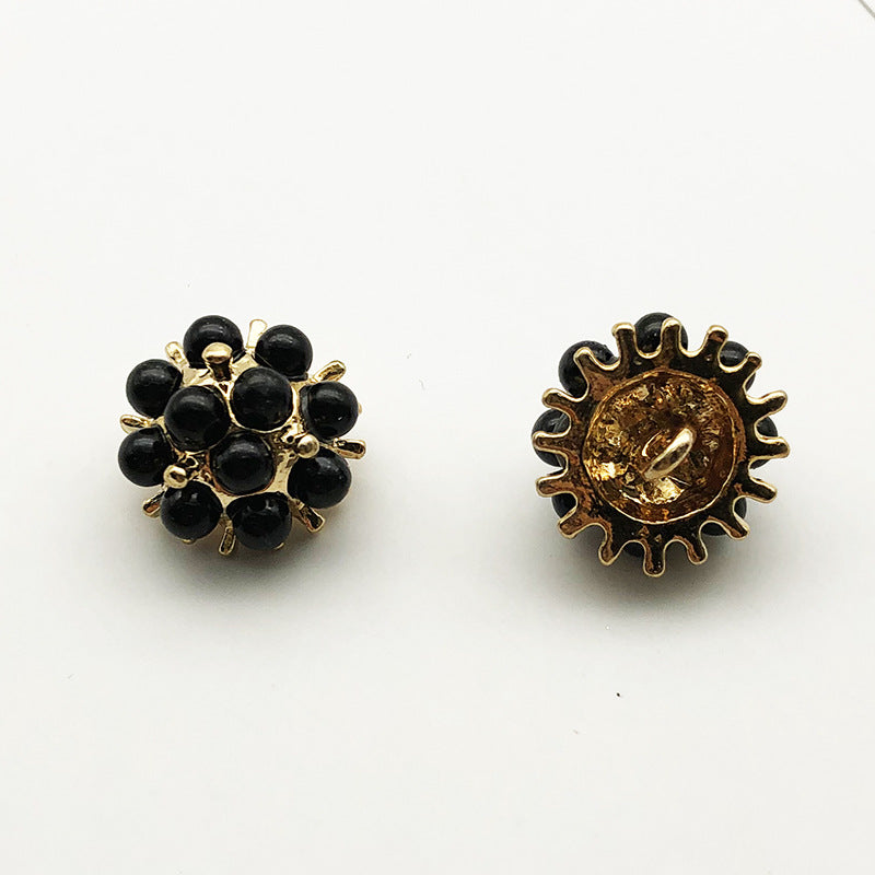 Black beaded sunflower shank button with gold-tone scalloped metal back.