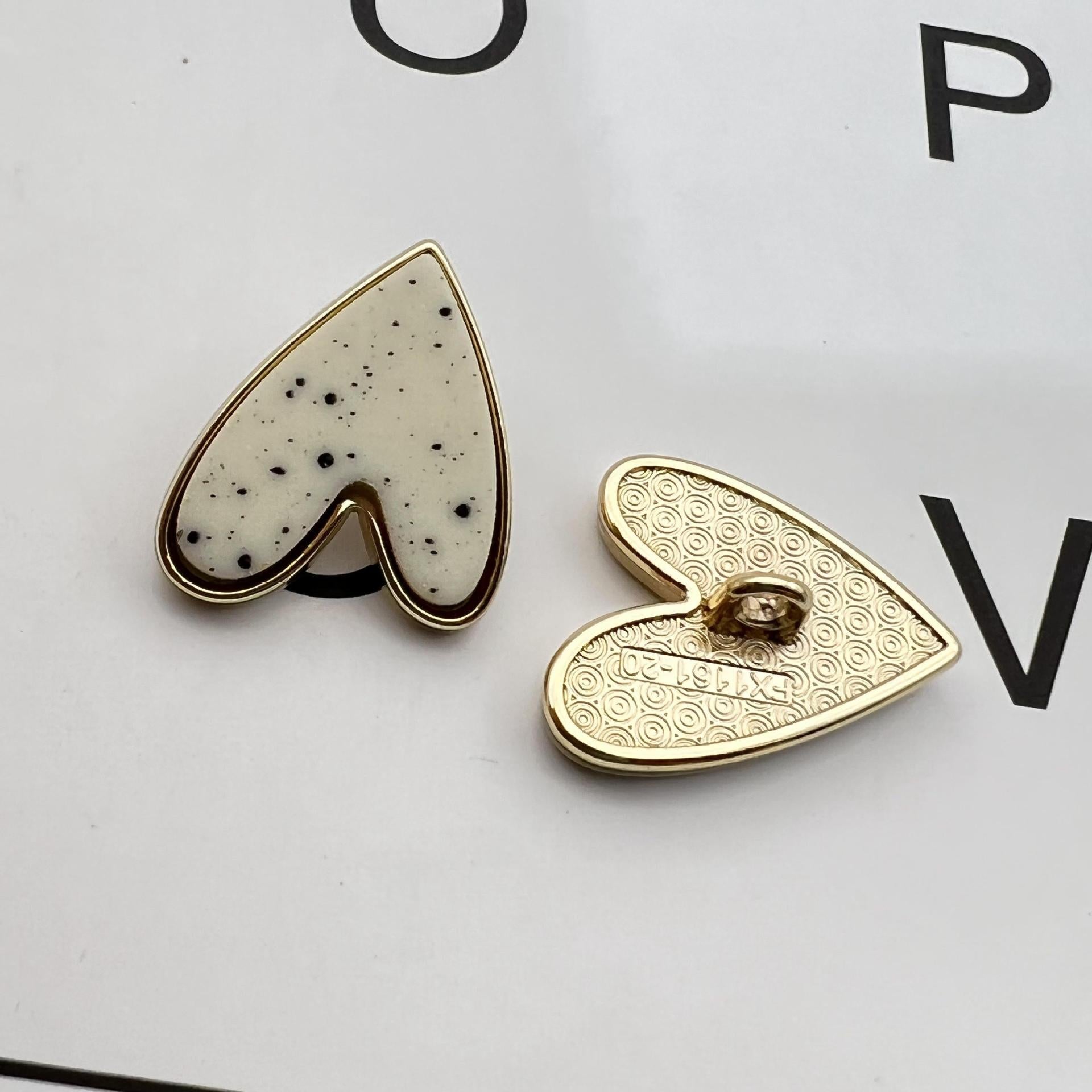 White starry heart metal shank button with gold edging, single piece