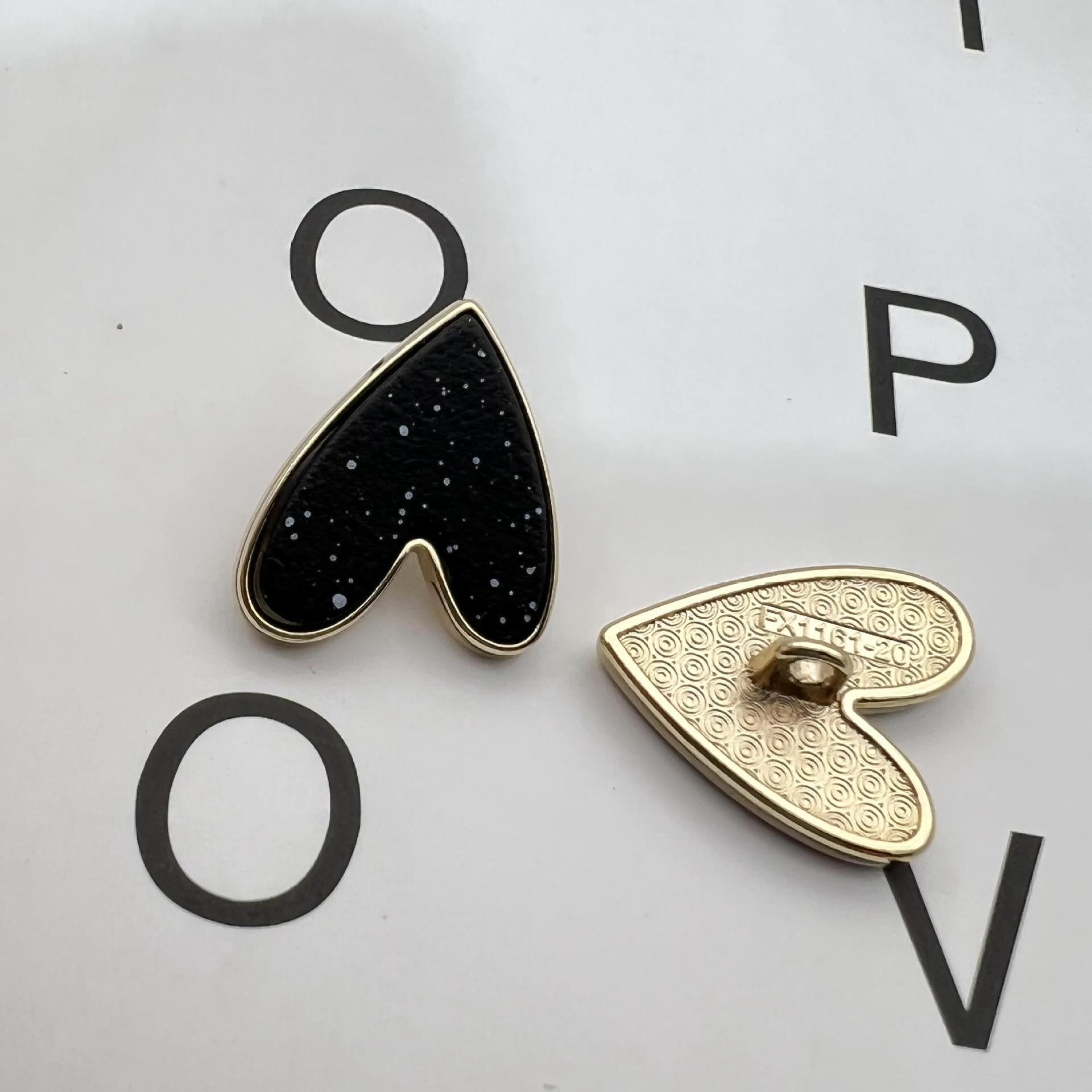 Black starry heart metal shank button with gold edging, single piece