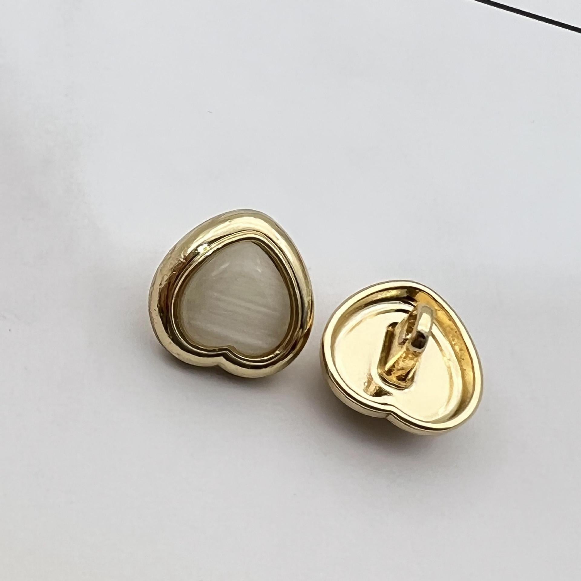 Heart-shaped pearlized resin button, white/cream center with gold metal shank and back