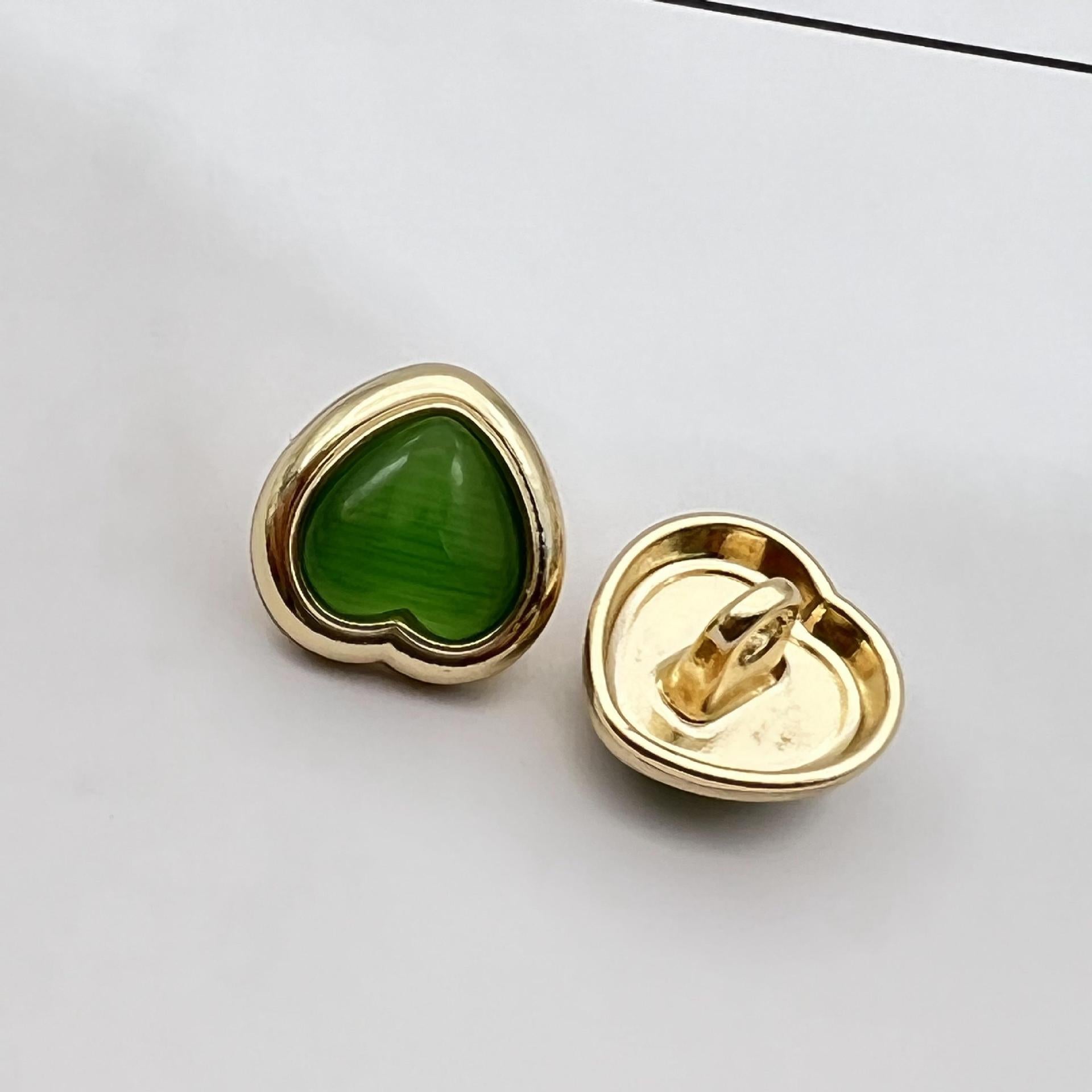 Heart-shaped pearlized resin button, green center with gold metal shank and back