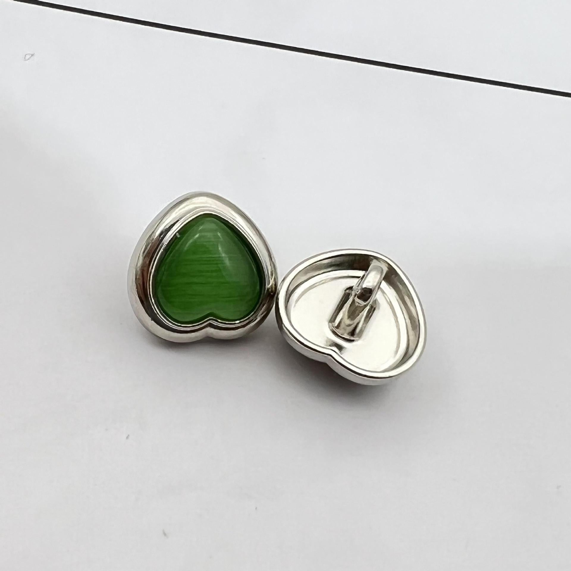 Heart-shaped pearlized resin button, green center with silver metal shank and back