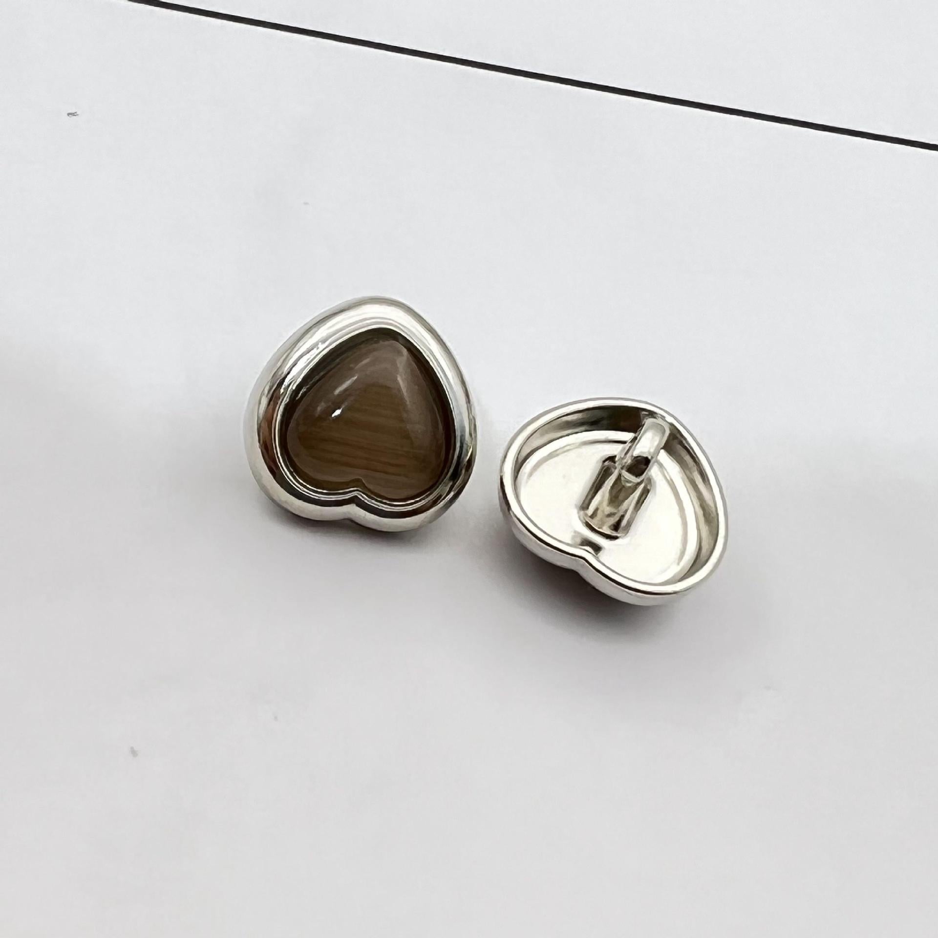 Heart-shaped pearlized resin button, dark coffee brown center with silver metal shank and back