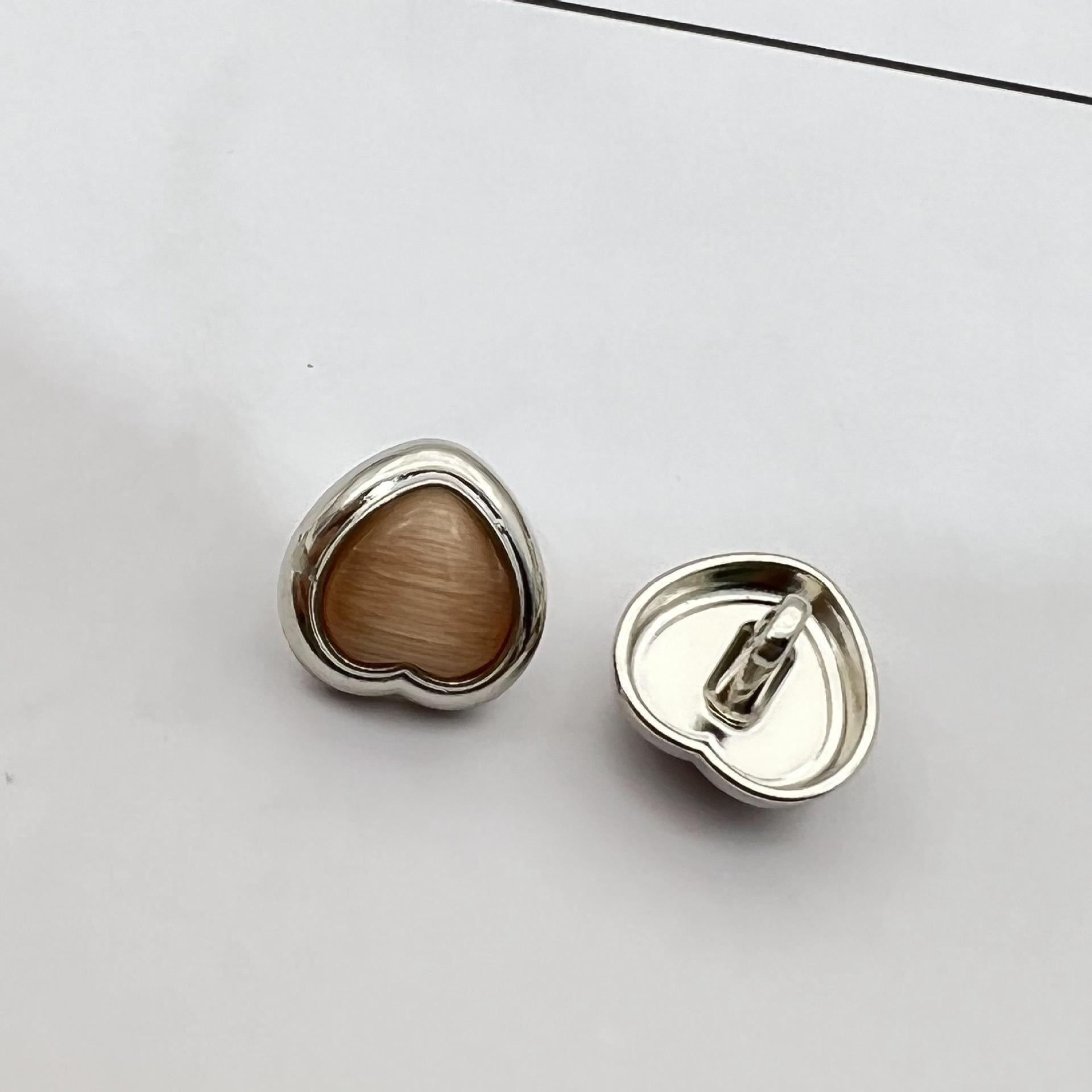 Heart-shaped pearlized resin button, taupe-brown center with silver metal shank and back