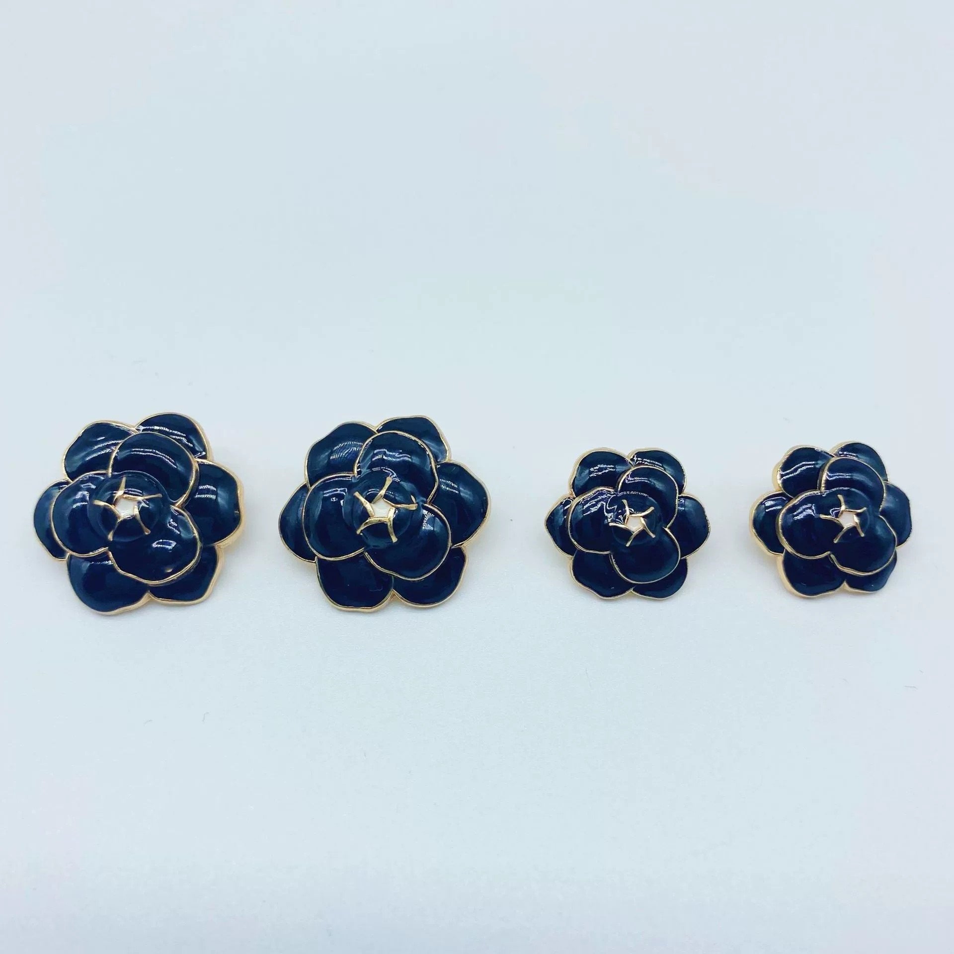 Black camellia metal buttons, gold-tone shank, glossy enamel, four shown
