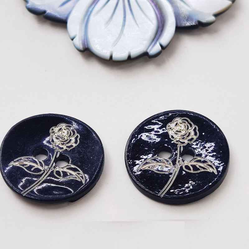 Pair of black printed mother-of-pearl buttons with rose-and-vine design, two holes