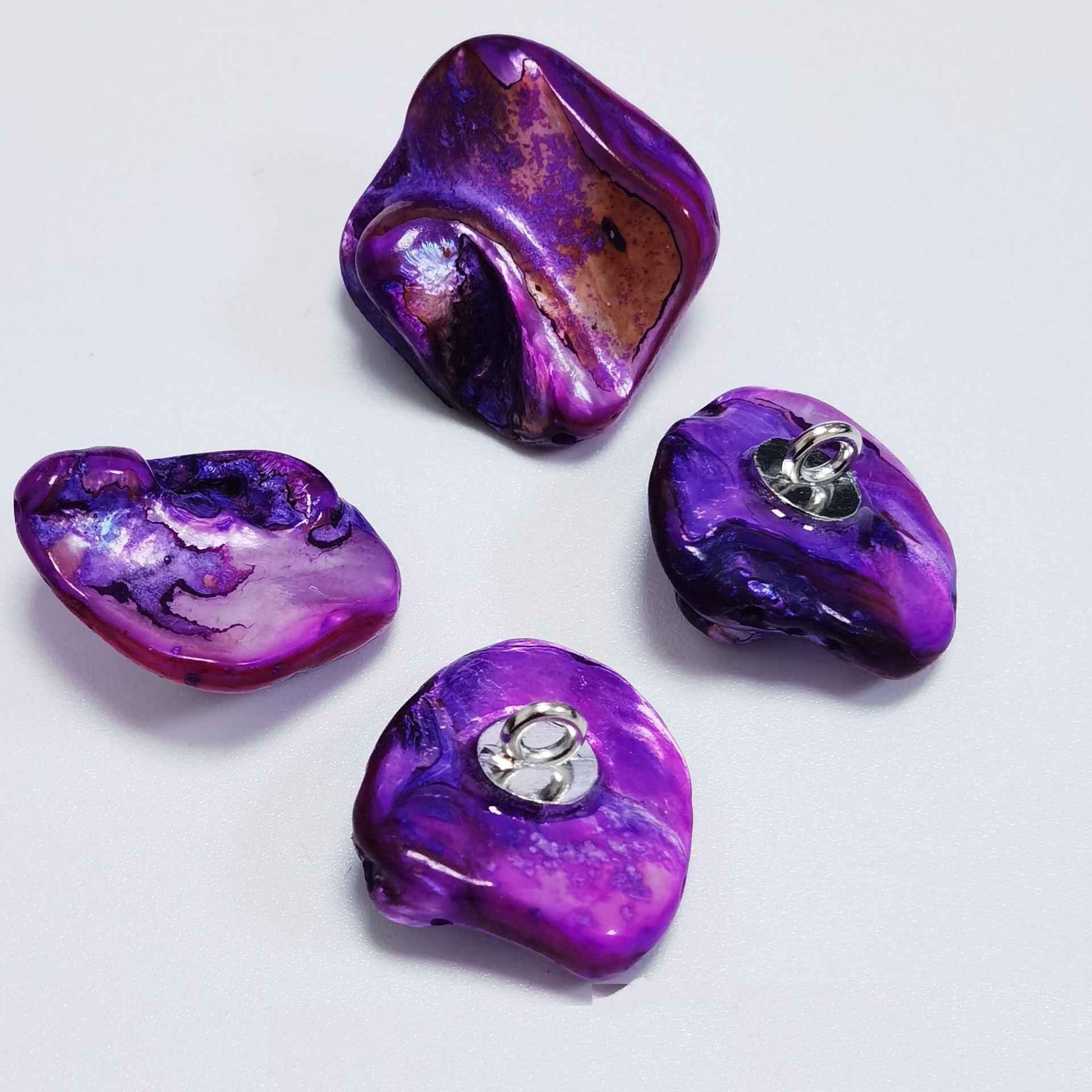 Purple irregular shell shank buttons with metal loop shanks, glossy pearly surface.