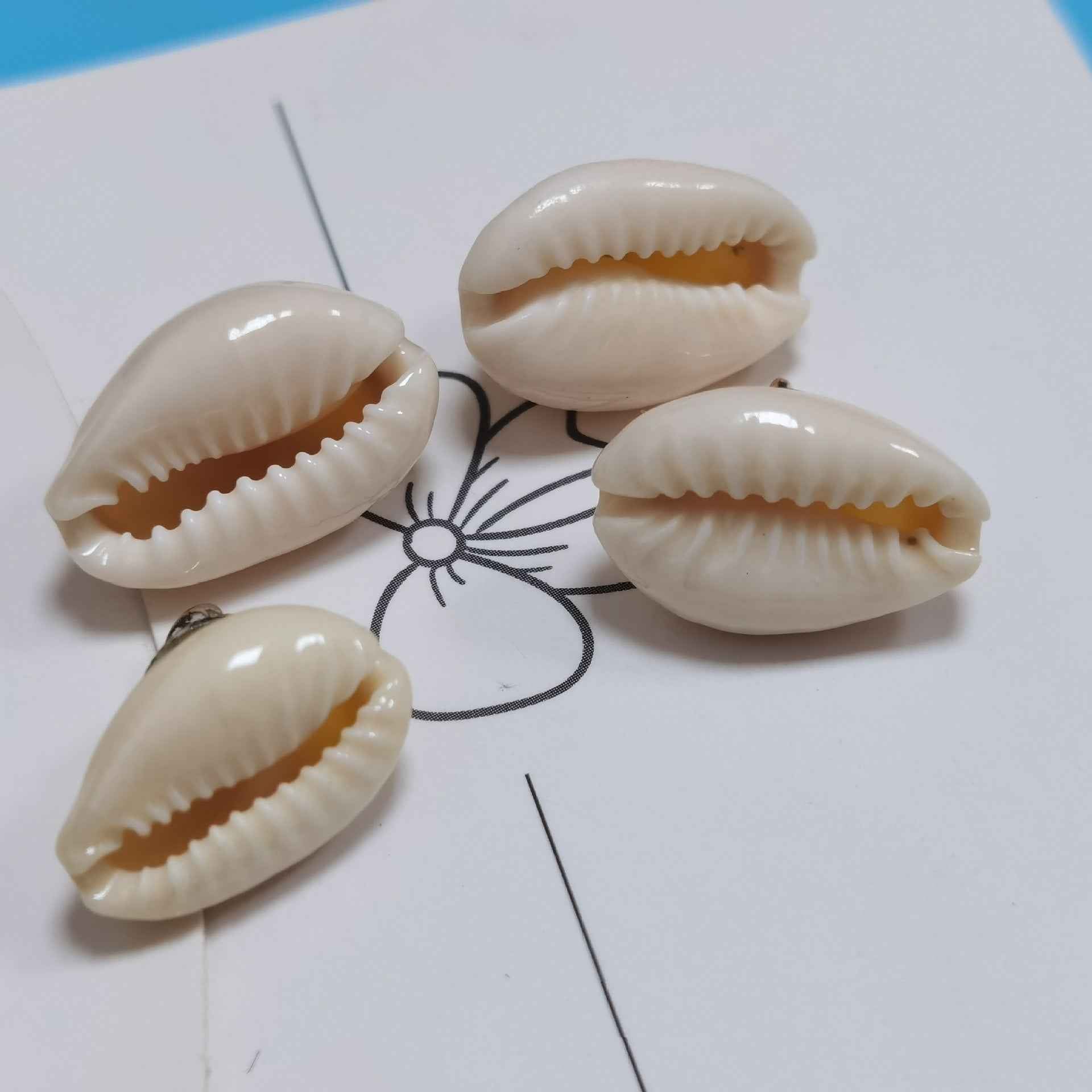 Close-up conch shell shank buttons: ridged cream shells with metal loop shanks