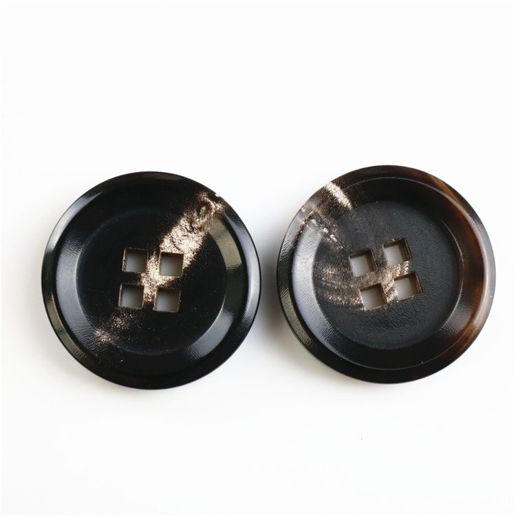 Round black buffalo horn buttons with four square holes, pair viewed from fronts