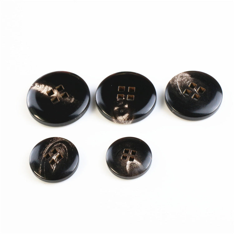 Set of round black buffalo horn buttons, four square holes, 5 buttons laid out