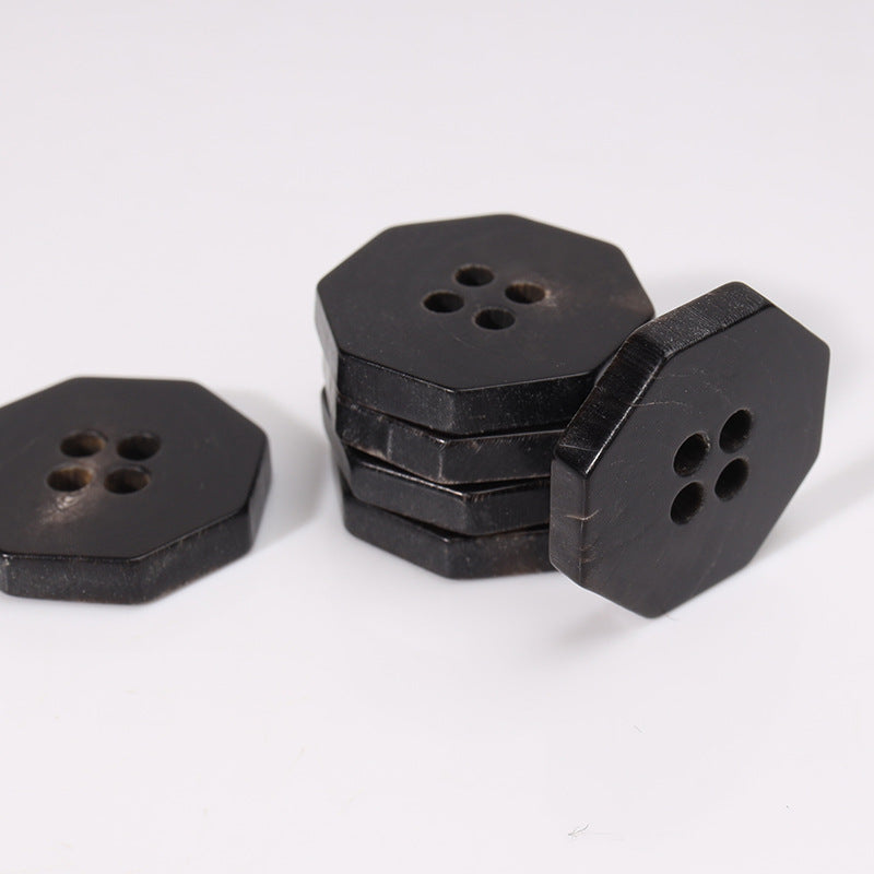 Stack of black octagonal 4-hole horn buttons, 20mm, showing depth and holes