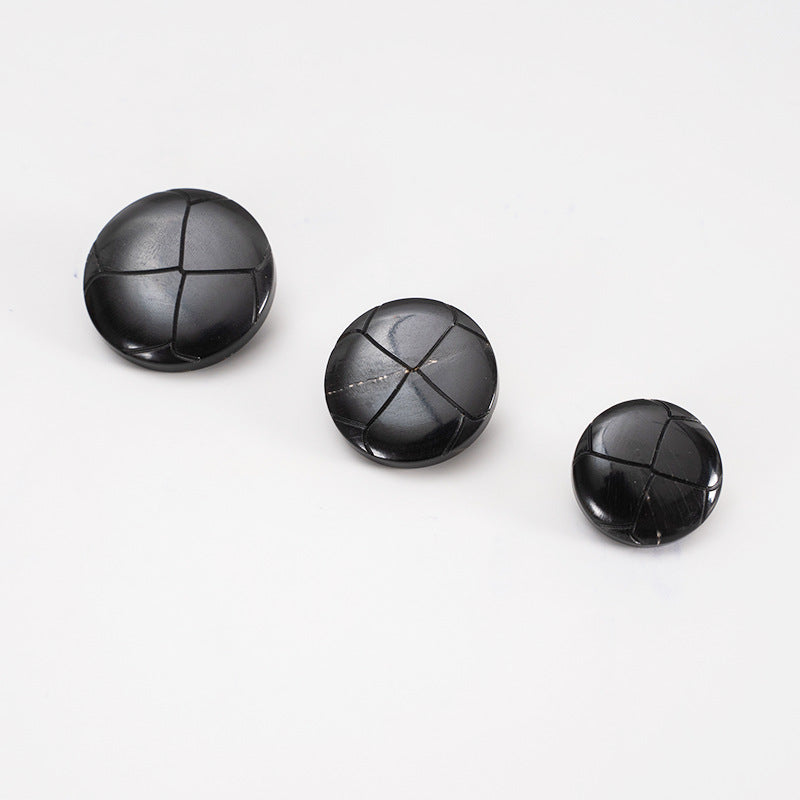 Three 25mm black round vintage buttons with panel seams, front sides