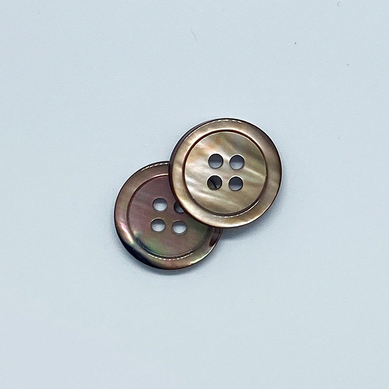 Two round 4-hole shell buttons with shiny metal-look rim, front views