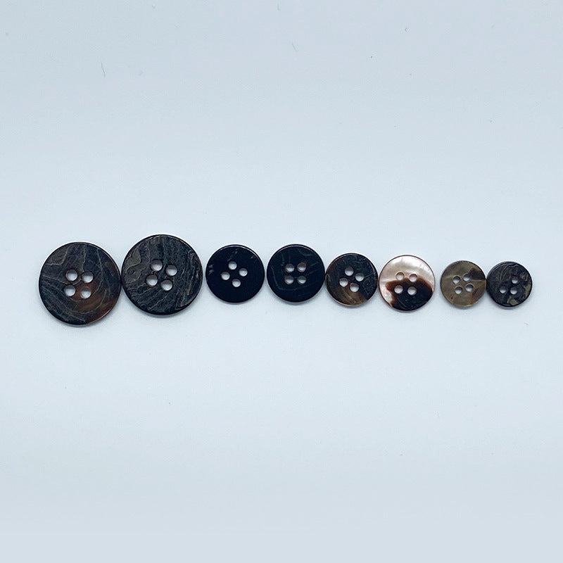 Series of round 4-hole shell buttons, coffee-toned, front sides in a row