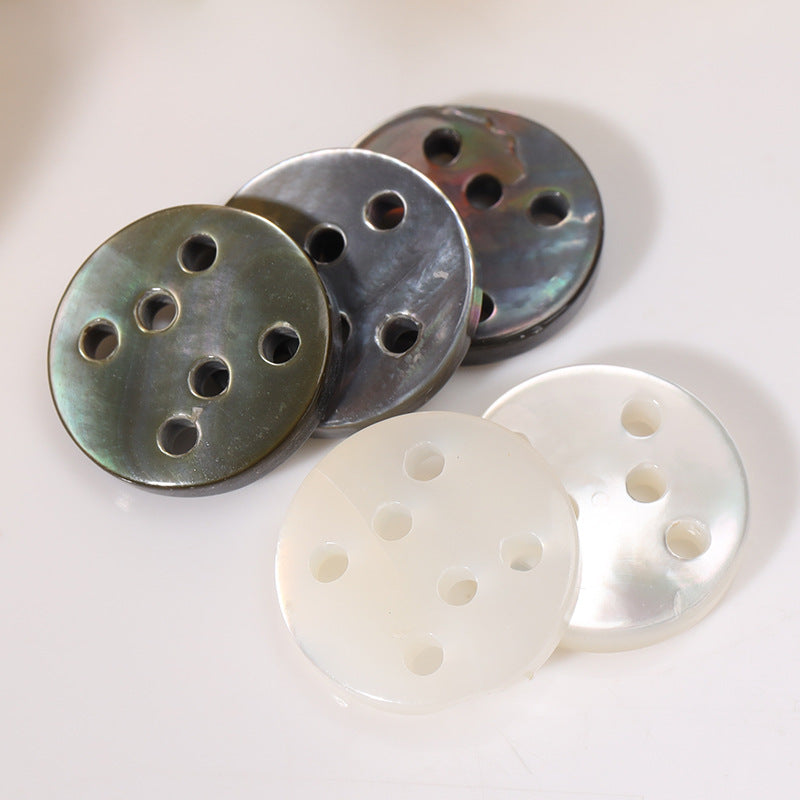 Set of round six-hole shell buttons in dark/black and white, each showing six holes