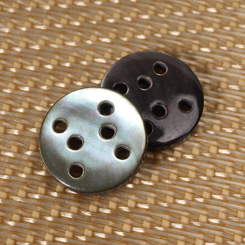 Round six-hole shell buttons, black and pale silver faces, each with six holes