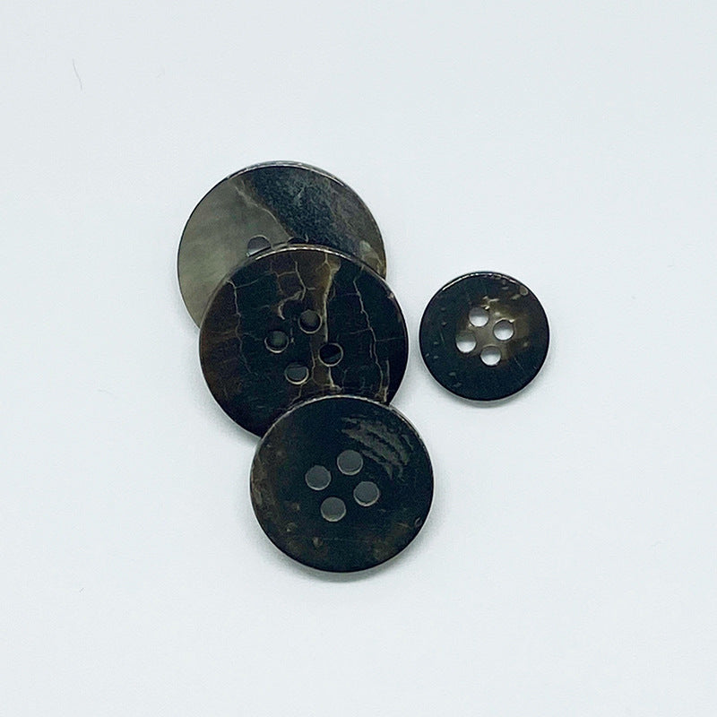 Black round 4-hole shell buttons with natural crackle pattern, 3 shown