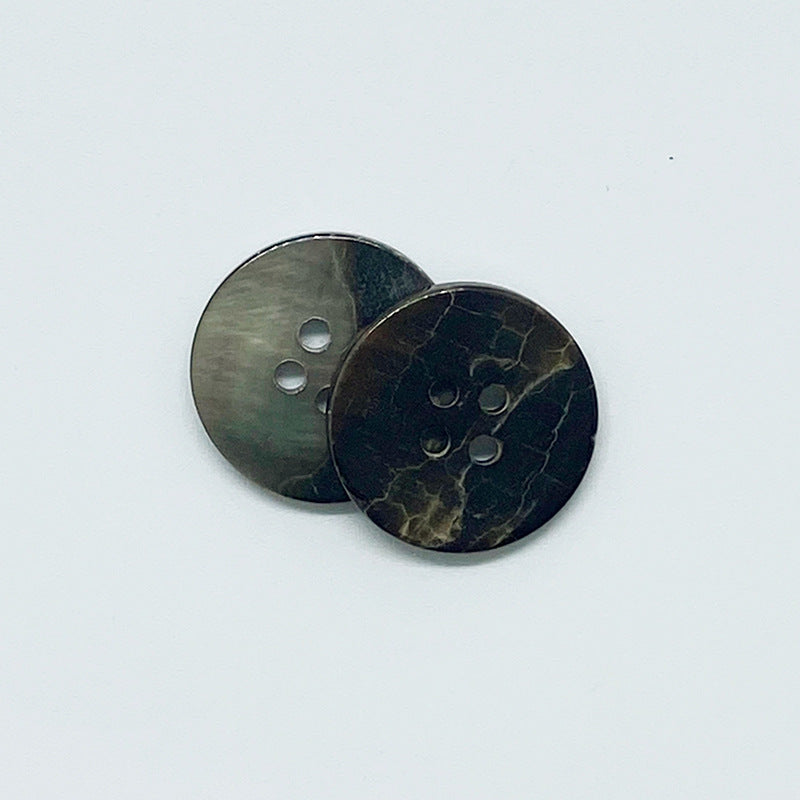 Two black round 4-hole shell buttons with crackle texture and iridescent sheen