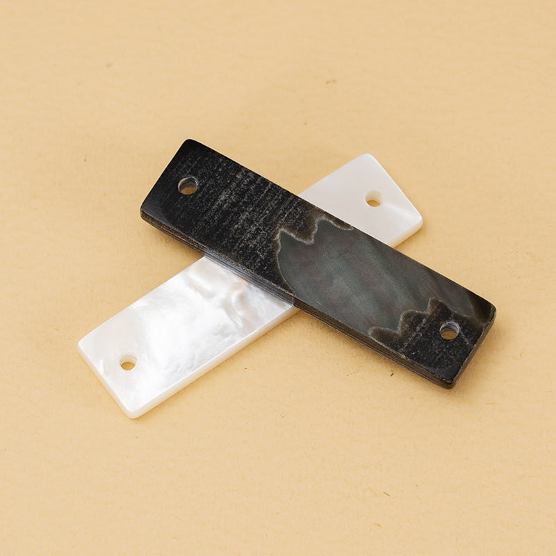 Wide-edge rectangular shirt buttons in dark and light shell, each with a sew hole