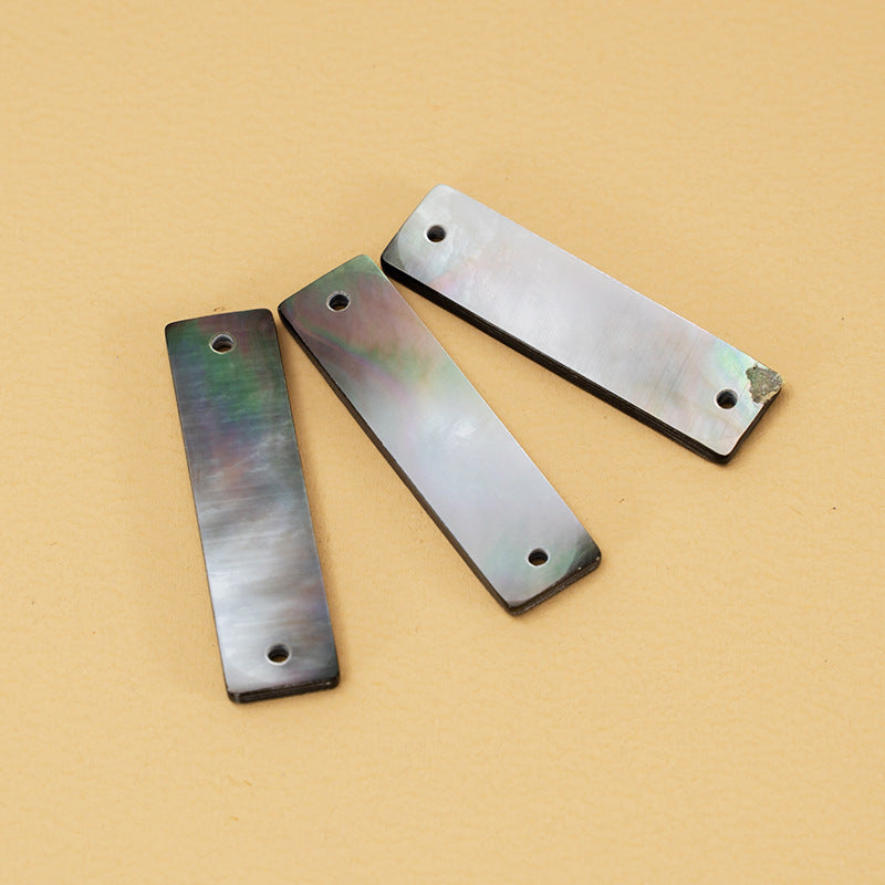 Wide-edge rectangular shell buttons with iridescent sheen and round sew holes