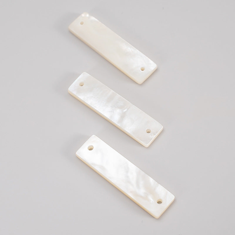 White rectangular shell buttons with wide edge and round sew holes