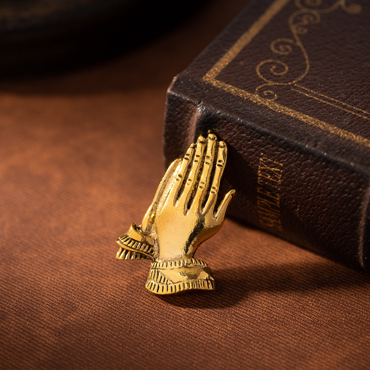Gold prayer hands lapel pin, front view with engraved-style detailing