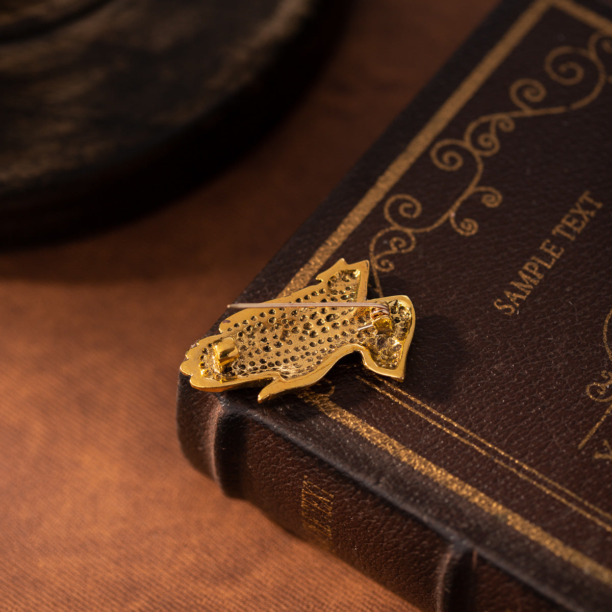 Gold-tone prayer hands lapel pin with detailed patterned finish