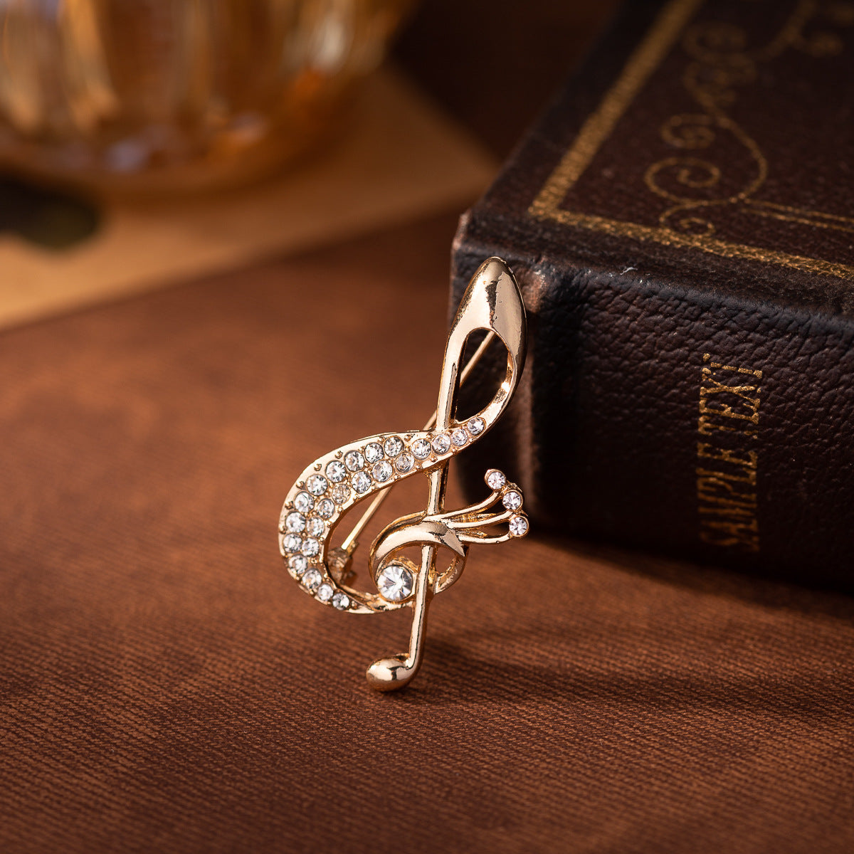 Gold diamond musical note brooch with rhinestone border