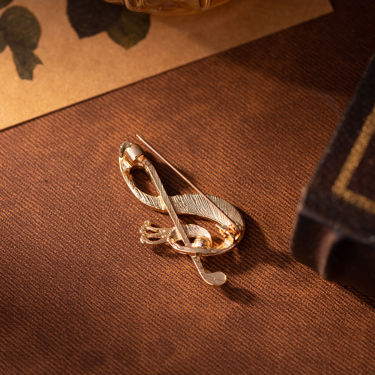 Gold-toned diamond musical note brooch with pin back