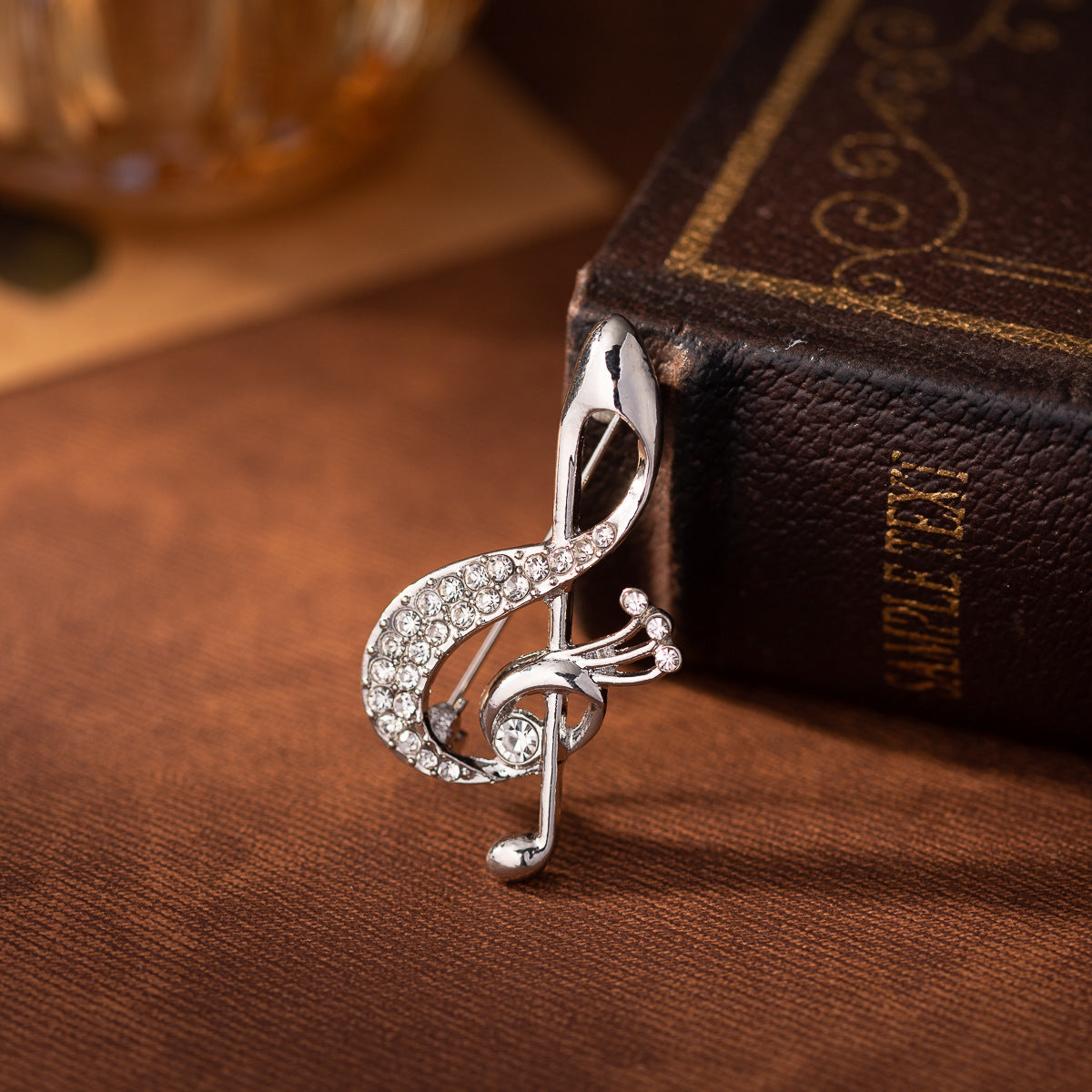 Silver diamond musical note brooch with rhinestone border