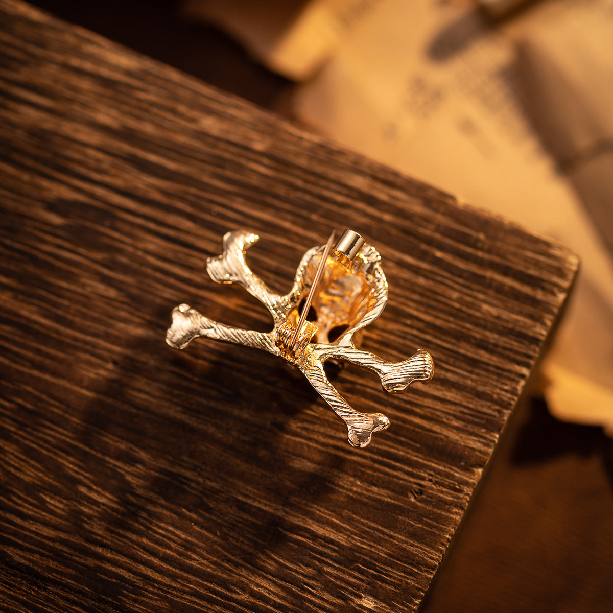 Gold skull crossbones metal brooch pin with back pin clasp, side view