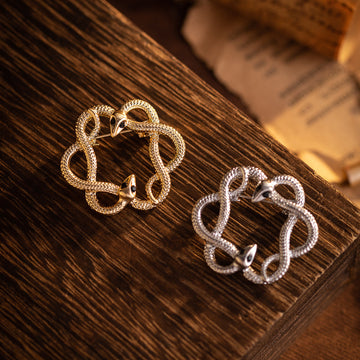 Gold retro flower-and-snake metal brooch, circular openwork with black eye accents