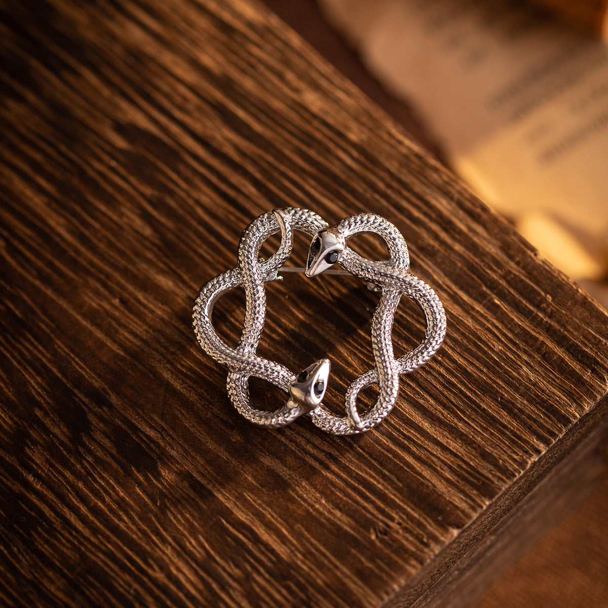 Silver retro flower-and-snake metal brooch, circular openwork with black eye accents