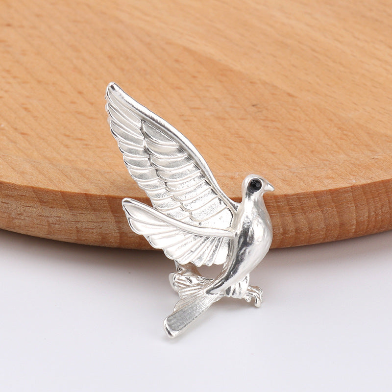 Silver dove metal brooch pin, winged bird motif with black eye detail