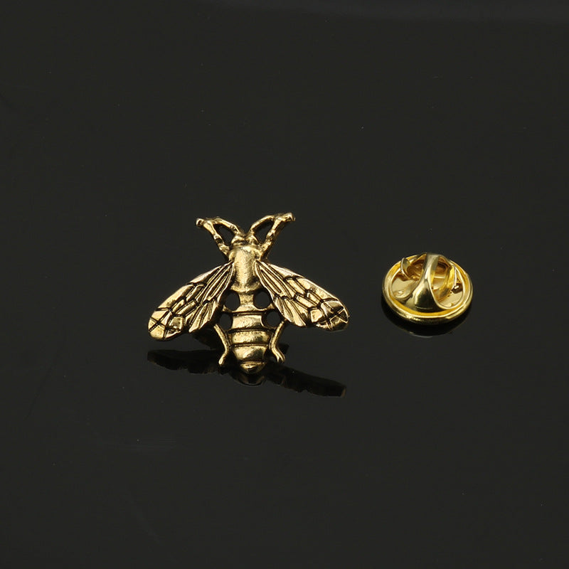 Gold-tone bee brooch pin with round locking back, textured wings and striped body