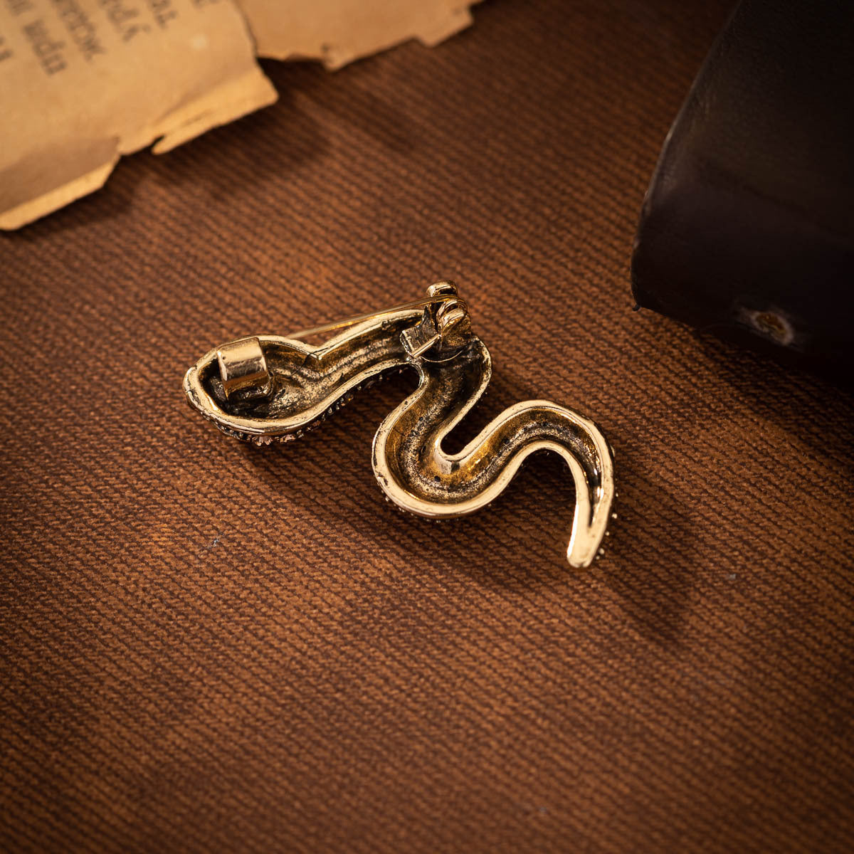 Gold-tone snake brooch pin pair with clasp backs and rhinestone details
