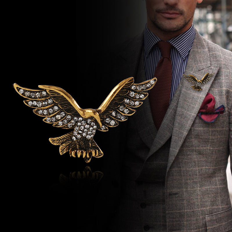 Gold-tone retro eagle wing brooch with rhinestone detailing on a blazer lapel
