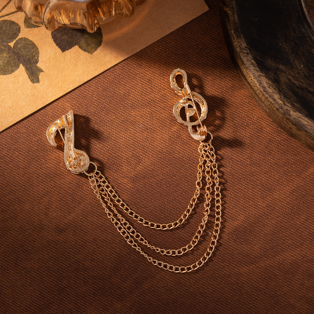 Gold-tone diamond music note brooch with tassel chain links, two-pack