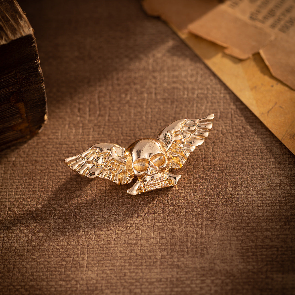 Gold winged skull brooch, side view with wings