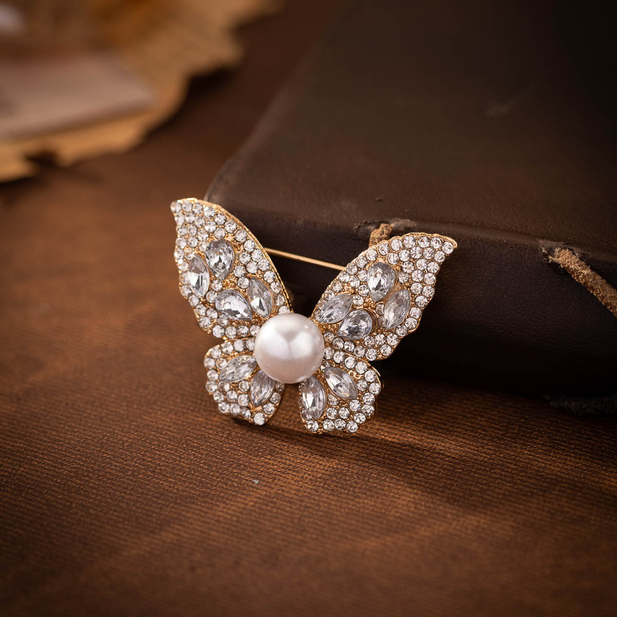 Diamond butterfly brooch with faux pearl and oval-cut crystal accents, silver-tone