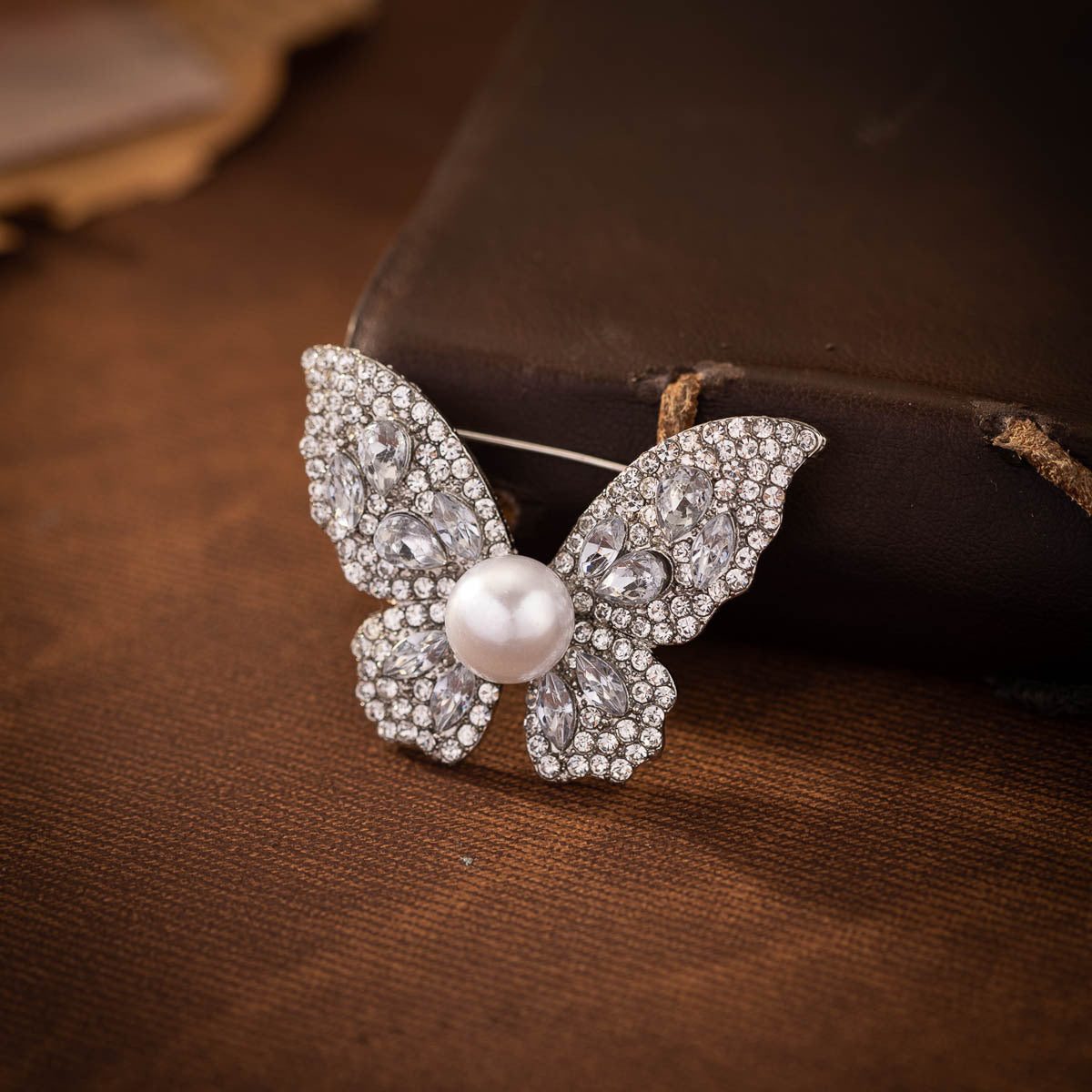 Diamond butterfly brooch with faux pearl, dense crystal pavé wings, front view