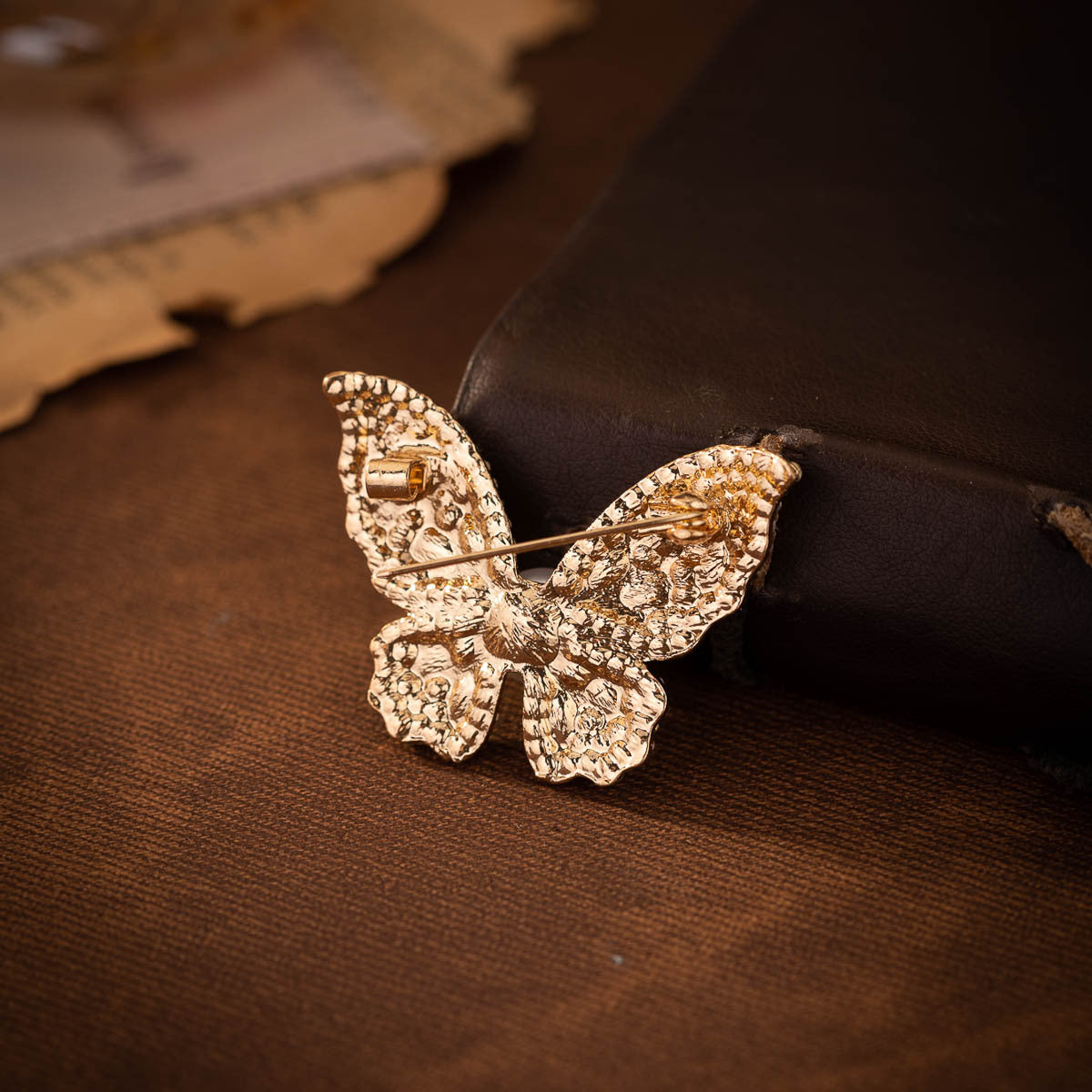 Gold-tone textured butterfly brooch pin with rhinestone pave, no pearl visible