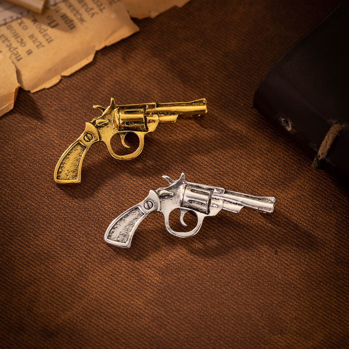 Retro revolver brooch pair: gold and silver-tone pistol designs with clasp