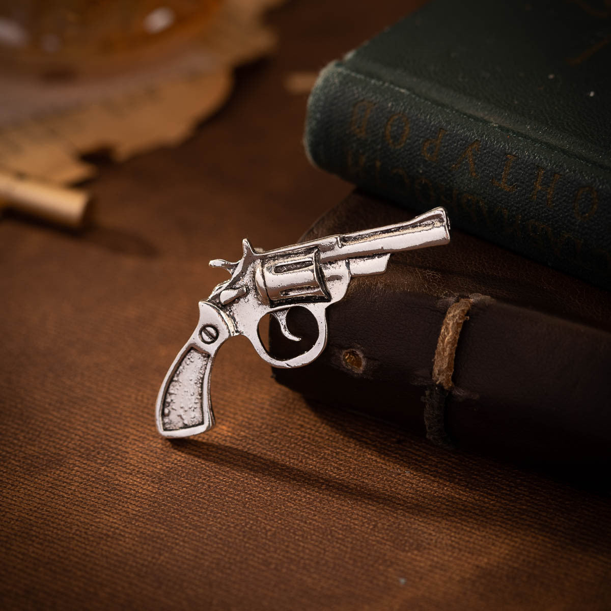 Silver-tone retro revolver brooch with textured grip and barrel detail