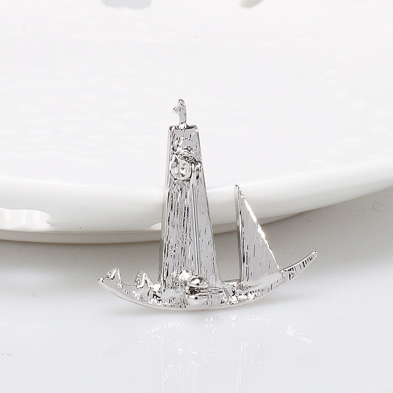 Silver-tone rhinestone sailboat lapel pin brooch with wave base